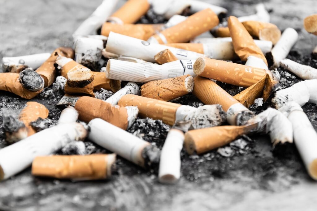 打造无烟世代 还有多少里路要走? 2 orange cigarette butts on black surface